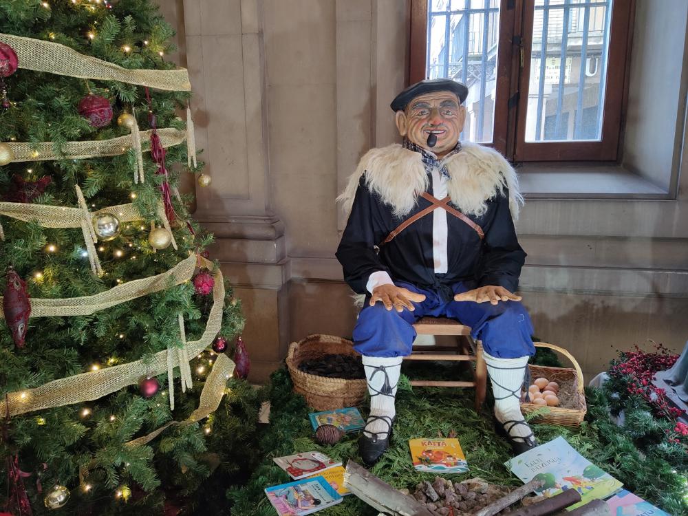 figura del Olentzero junto a un árbol de navidad
